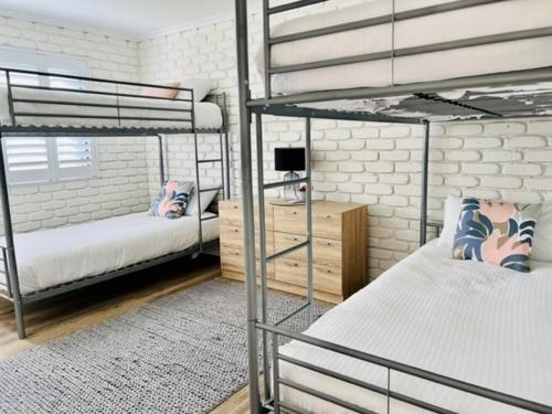 sypialnia z 2 łóżkami piętrowymi i biurkiem w obiekcie Mooloolaba Waterfront Unit - sleeps 8 w mieście Mooloolaba