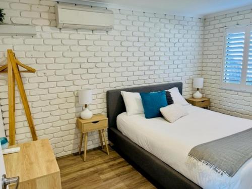 a bedroom with a bed and two tables with lamps at Mooloolaba Waterfront Unit - sleeps 8 in Mooloolaba