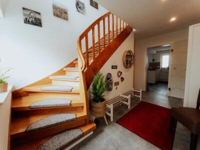a room with a staircase with pillows and a plant at Welcome Haus Allgäu in Memmingen