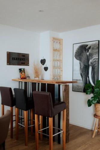 a bar in a room with a table and chairs at Welcome Haus Allgäu in Memmingen