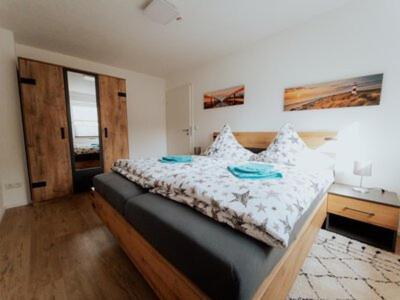Schlafzimmer mit einem großen Bett mit einem Kopfteil aus Holz in der Unterkunft Welcome Haus Allgäu in Memmingen