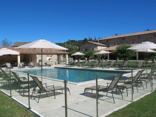 - une piscine avec des chaises et des parasols à côté d'un bâtiment dans l'établissement NOUVEAU Villa Olga, à Jaujac