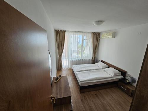 a small bedroom with a bed and a window at Apartment Fort Noks in Sveti Vlas