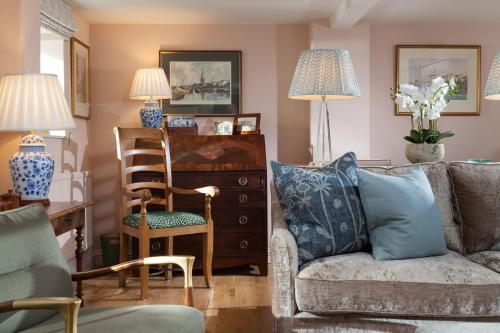 a living room with a couch and a chair at Wisteria Cottage in Urchfont