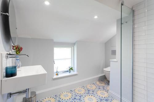 a bathroom with a sink and a toilet at Wisteria Cottage in Urchfont