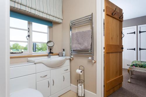 a bathroom with a sink and a window at Radcot Bridge Cottage in Radcot