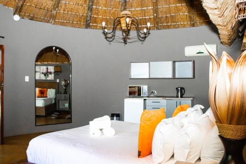 a bedroom with a white bed and a mirror at Mela Luxury Game Lodge in Pretoria