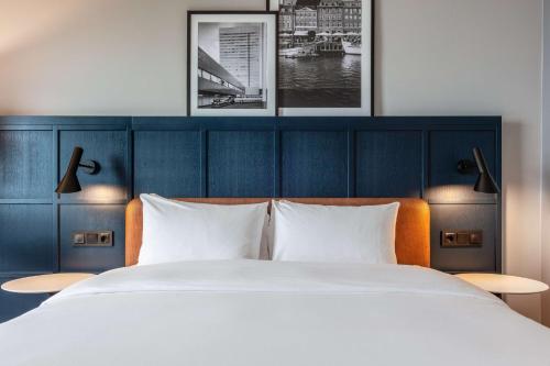 a bedroom with a large bed and two pictures on the wall at Radisson Blu Scandinavia Hotel, Copenhagen in Copenhagen