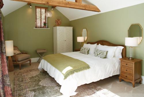 a bedroom with a large white bed and a chair at Woodland Retreat in Burton upon Trent