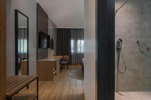 a bathroom with a shower and a desk in a room at Park Inn by Radisson, Lagos Victoria Island in Lagos