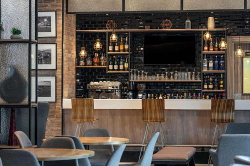 a bar with tables and chairs and a television at Park Inn by Radisson, Lagos Victoria Island in Lagos