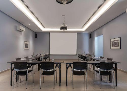 a conference room with a table and chairs and a projection screen at Park Inn by Radisson, Lagos Victoria Island in Lagos