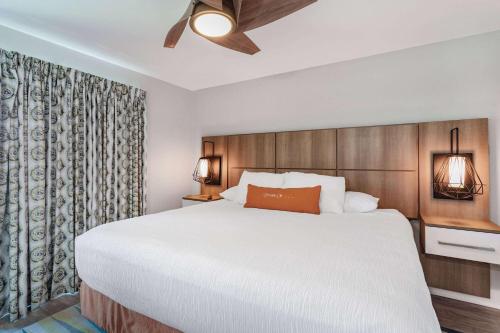 - une chambre avec un grand lit et un ventilateur de plafond dans l'établissement Coconut Palms Beach Resort II a Ramada by Wyndham, à New Smyrna Beach