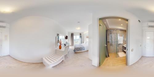 a white room with a mirror and a bedroom at Golden Lion Parga in Parga
