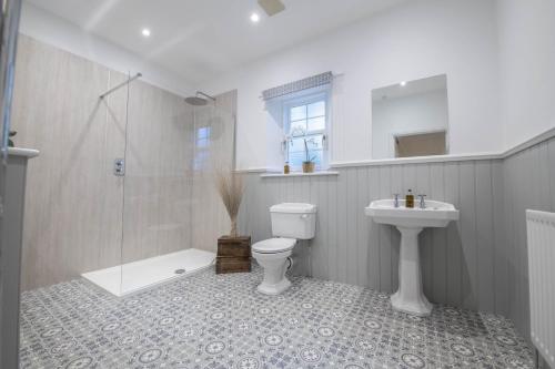 a bathroom with a toilet and a shower and a sink at Eslington Lodge in Alnwick