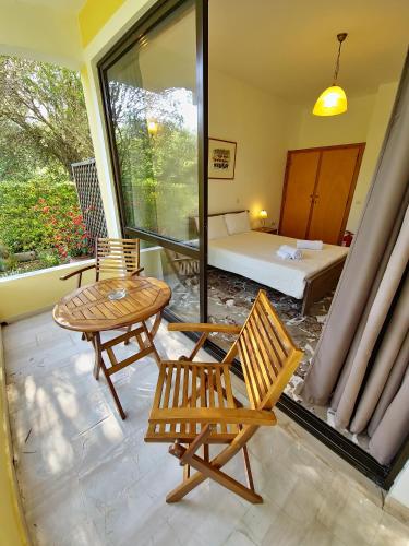 una habitación con una mesa y dos sillas y una cama en Alexandra Studio 8, en Lefkimmi
