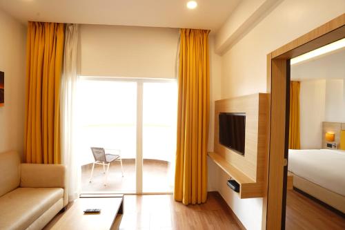 a hotel room with a bed and a couch at BloomSuites l Calangute in Calangute