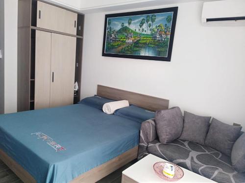 a small bedroom with a bed and a couch at Apartments in Star Bay with sea view in Sihanoukville