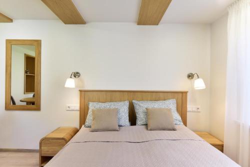 a bedroom with a large bed with a mirror at SMILTIS in Palanga