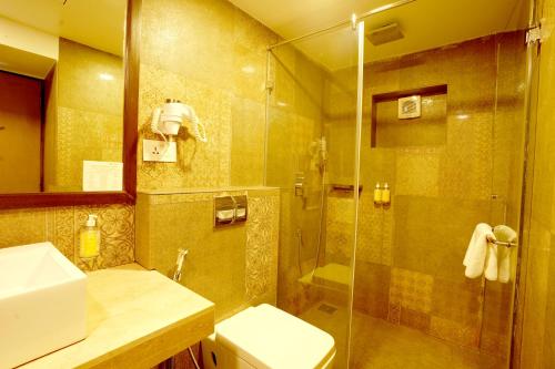 a bathroom with a shower and a toilet and a sink at BloomSuites l Calangute in Calangute