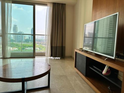 a living room with a television and a large window at MyHabitat - KLCC 2 bedroom in Kuala Lumpur