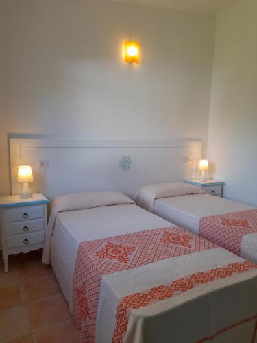 波薩達的住宿－Maria Caderina House，两张床位于带两盏挂在墙上的灯的房间