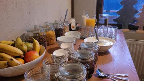 a wooden table topped with a bowl of fruit and jars at Haus Grübl in Wald im Pinzgau