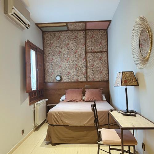 a bedroom with a bed and a table with a lamp at Hotel Sol in Toledo