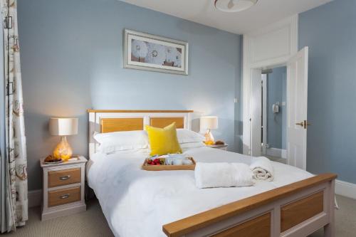ein Schlafzimmer mit einem großen weißen Bett mit gelben Kissen in der Unterkunft Veronica Cottage in Swanage
