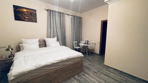a bedroom with a large bed and a table at Altunyan Hotel in Yerevan