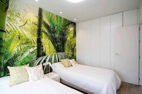 two beds in a room with a mural on the wall at Preciosa villa con la piscina en las Colinas in Orihuela
