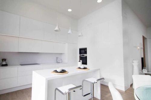 a white kitchen with white cabinets and a counter at Preciosa villa con la piscina en las Colinas in Orihuela