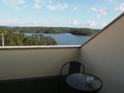 - Balcón con mesa y silla y vistas al lago en AL Restaurante A Lampreia, en Santa Comba Dão