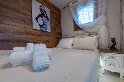 Un dormitorio con una cama blanca con toallas. en Zikas Family's House, en Leptokarya