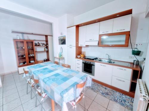 a kitchen with a table and a kitchen with white cabinets at Puzzle al Mare in Follonica