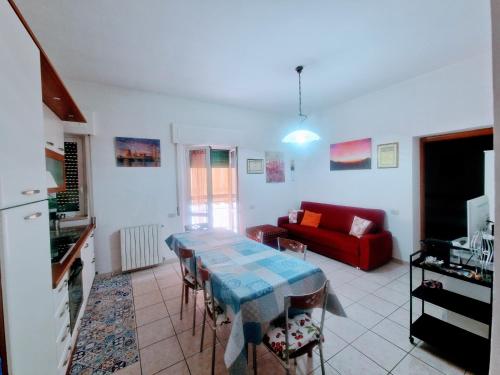 a living room with a table and a red couch at Puzzle al Mare in Follonica