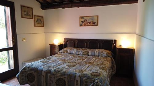 a bedroom with a bed and two lamps and a window at Locanda le Mandriane in Albinia