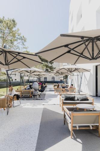 a group of tables and umbrellas with people sitting in them at briig boutique hotel in Split