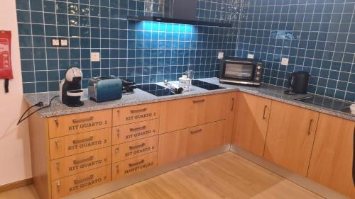 a kitchen with blue tiled walls and a counter with boxes at AL Restaurante A Lampreia in Santa Comba Dão