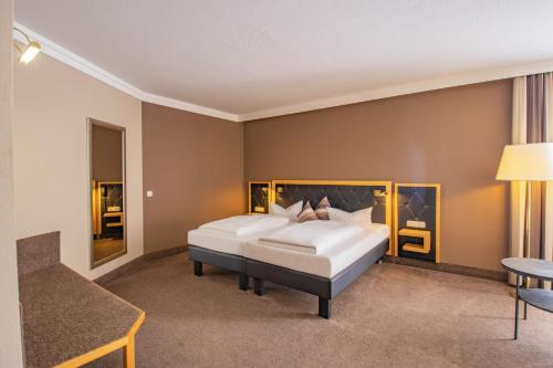 a bedroom with two beds and a table at Hotel Tanne in Ilmenau