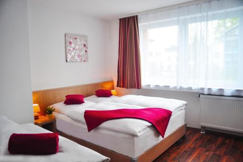 a bedroom with two beds and a window at Hotel Platinium in Aachen
