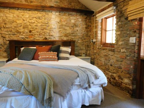 um quarto com uma cama numa parede de pedra em Tara Stables em Littlehampton