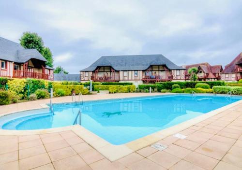une grande piscine devant une maison dans l'établissement L'Ancre Rouge Deauville, à Deauville