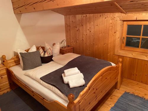 una camera da letto con un letto in legno e asciugamani di Au Alm a Söll