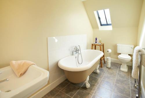 une salle de bain avec une baignoire, un lavabo et des toilettes dans l'établissement Woodland Cottage Devon, à Romansleigh