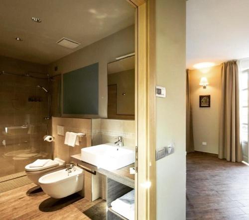 La salle de bains est pourvue de toilettes et d'un lavabo. dans l'établissement Hotel Monteverde, à Acqui Terme