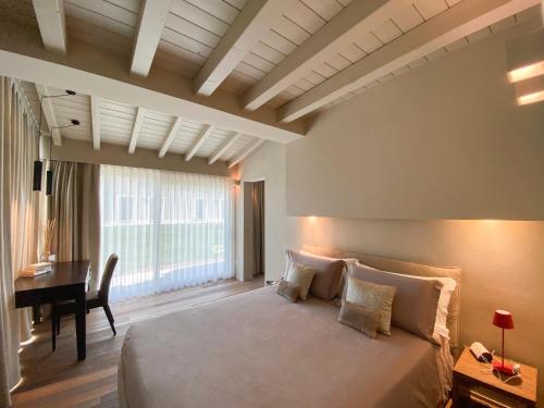 - une chambre avec un grand lit et un bureau dans l'établissement Time to Relax - Lago di Garda - Adults only, à Ponti sul Mincio