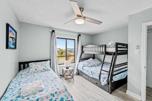 a bedroom with two bunk beds and a balcony at La LuNa in Corolla