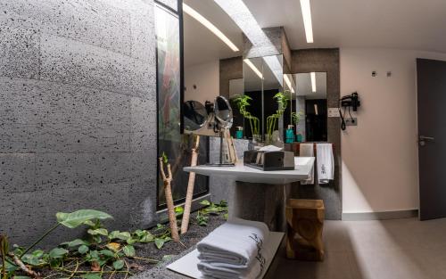 a bathroom with a sink and a shower with plants at La Isla y el Mar, Hotel Boutique in Puerto del Carmen