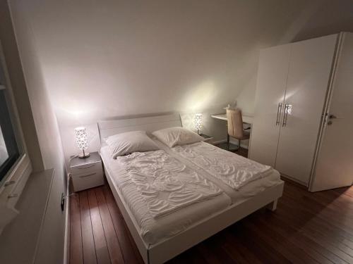 グロヴェにあるFerienhaus Sarcanderのベッドルーム(白いベッド1台、テーブル、椅子付)